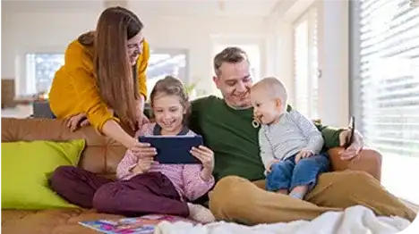 young caucasian family relaxing on sofa using tablet