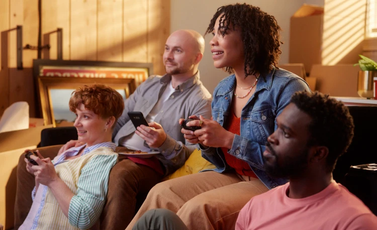 A group of people look at the tv while a woman in the middle plays a video game.