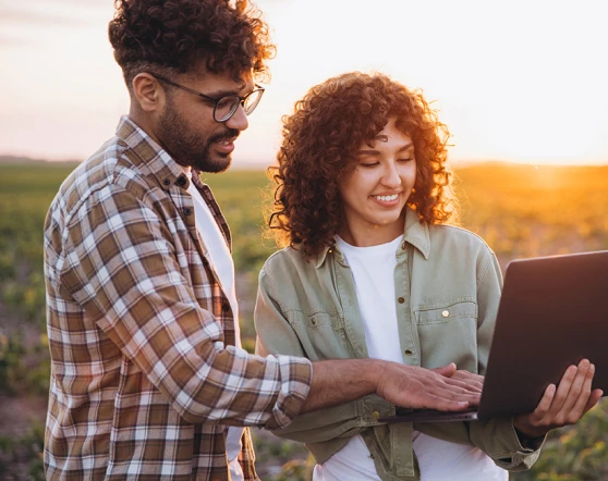 Two colleagues reviewing a laptop outdoors