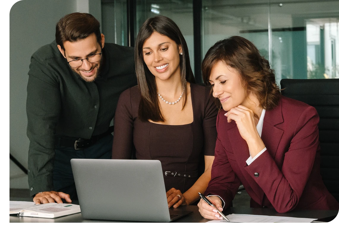 Team collaborating around a laptop