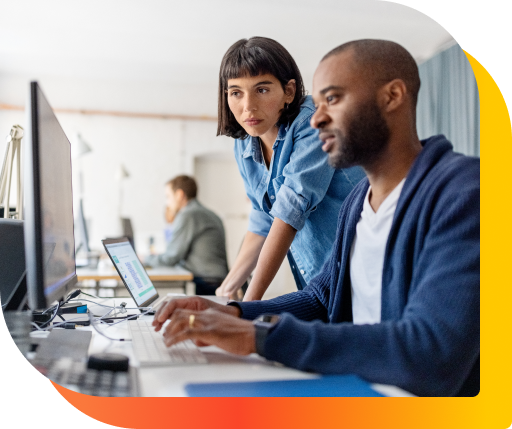 Two professional in an office setting looking a computer together