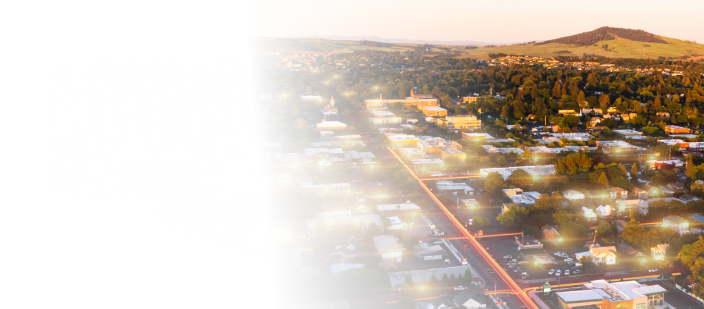 Aerial view of a suburban town surrounded by trees and hills