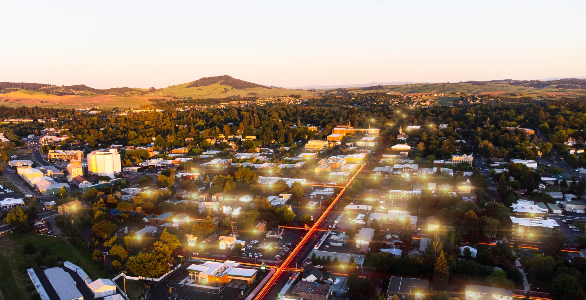 Aerial view of a suburban town surrounded by trees and hills