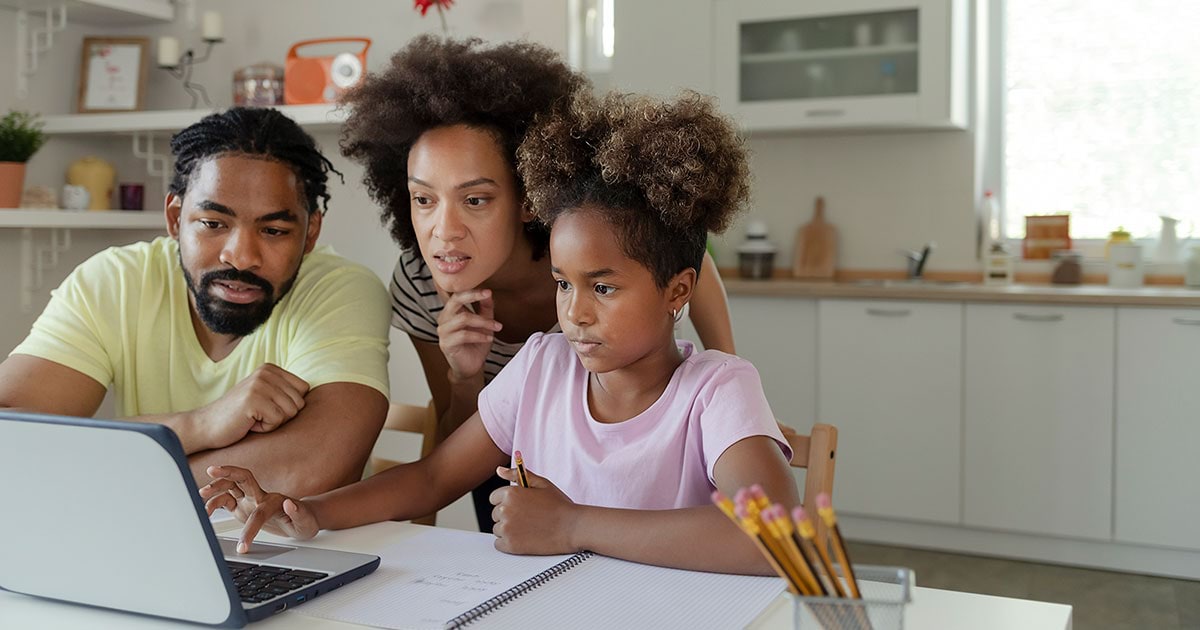 A family looks at a laptop together at the table