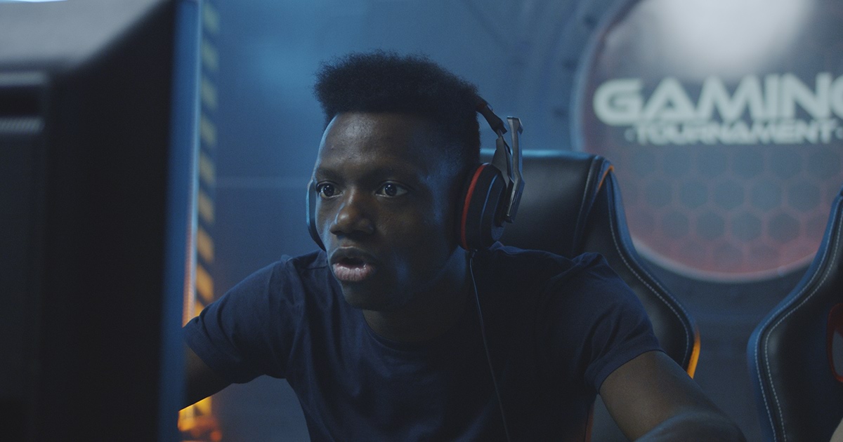 A young man is engrossed in playing an online game
