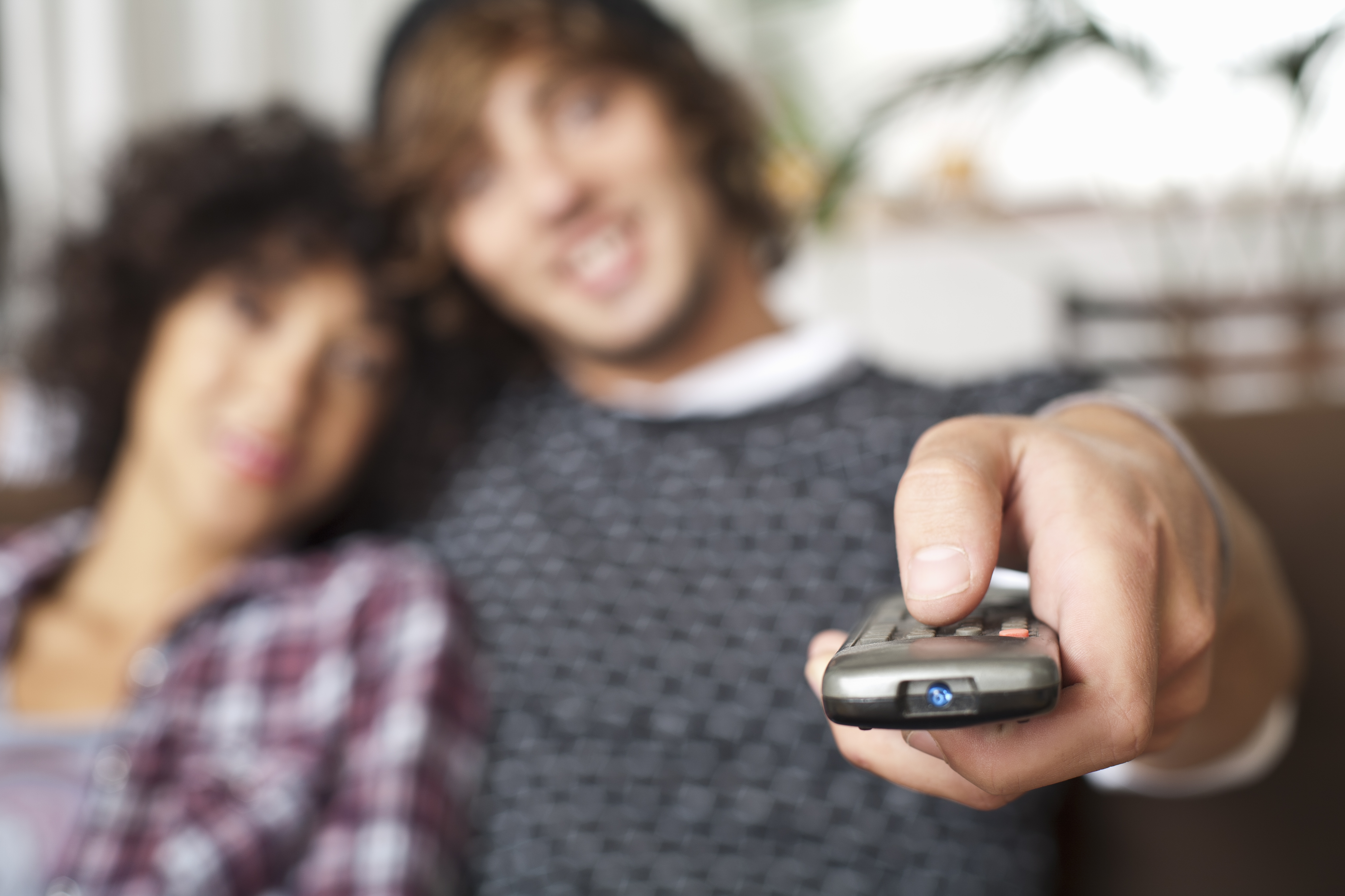 couple facing tv with a remote