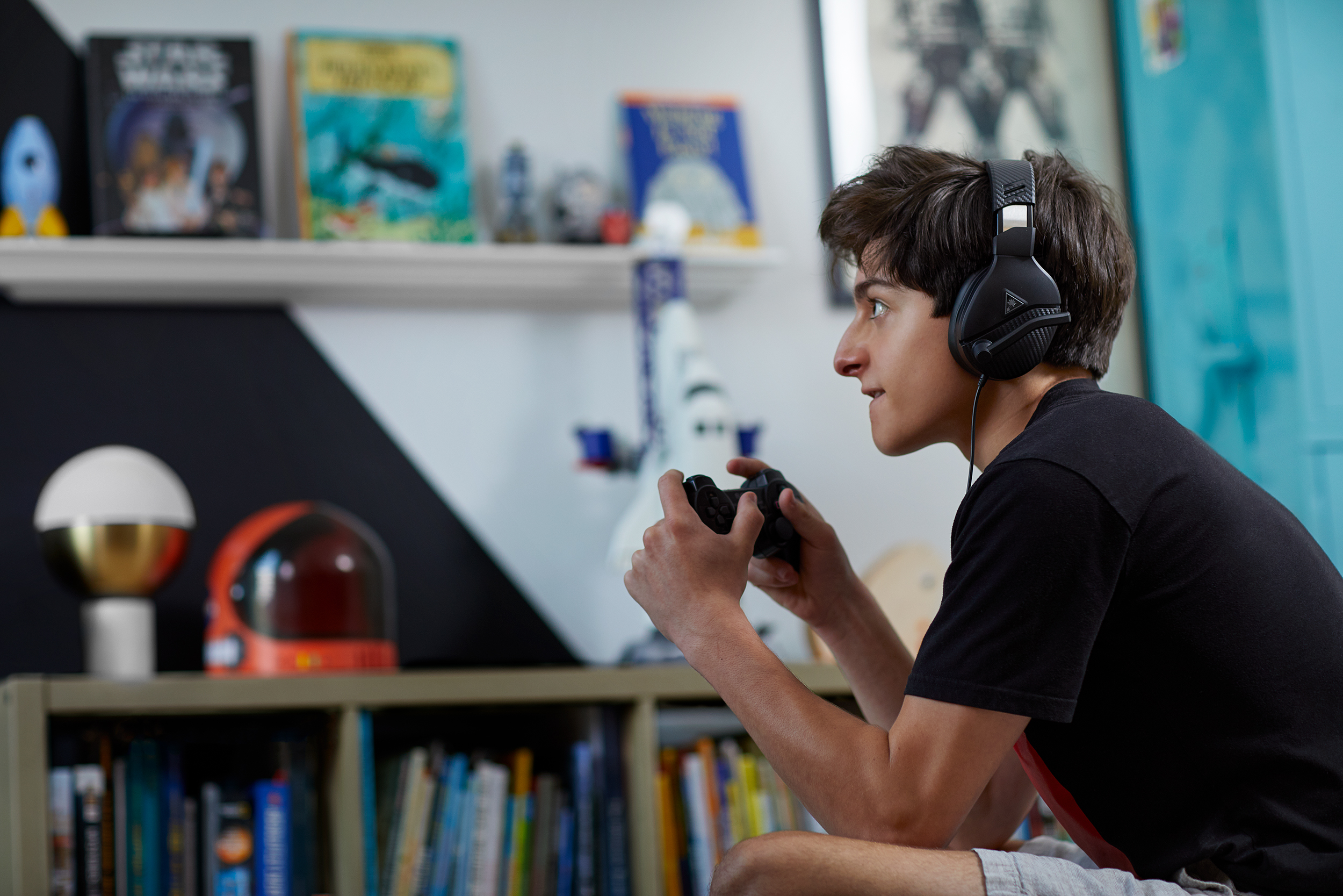 Teenager intensly plays video game.